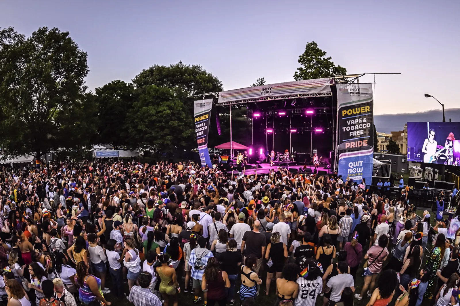 Large crowd enjoying a live concert at the Indy Pride main stage during the evening celebration