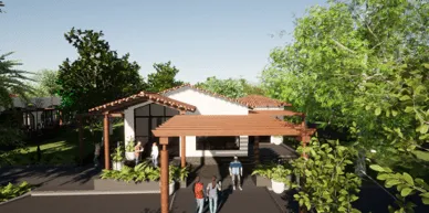 Three people standing near the entrance of a single-story house with a wooden pergola and surrounding greenery.