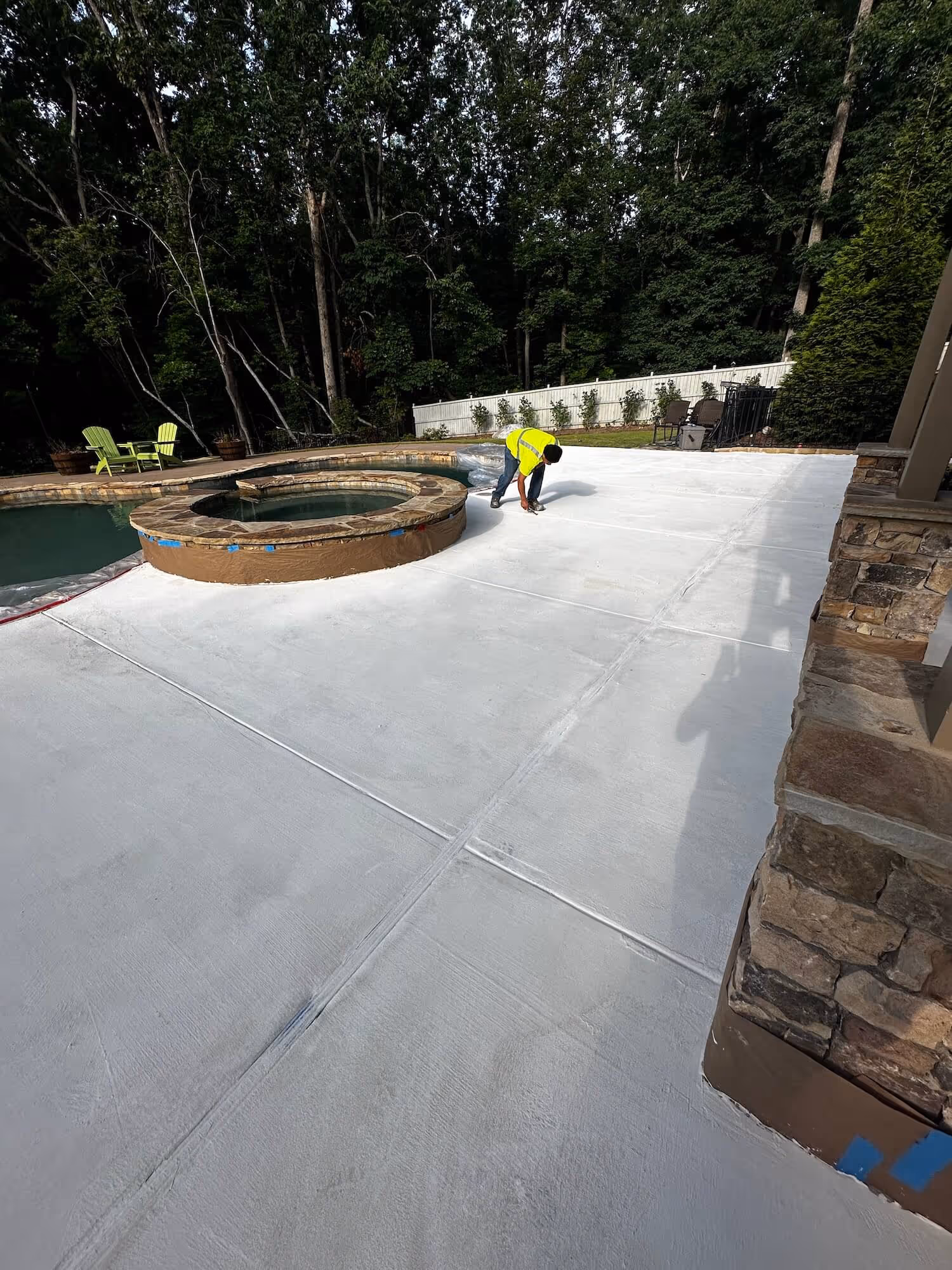 epoxy Flooring experts refinishing a large white concrete pool deck in Atlanta, ga.