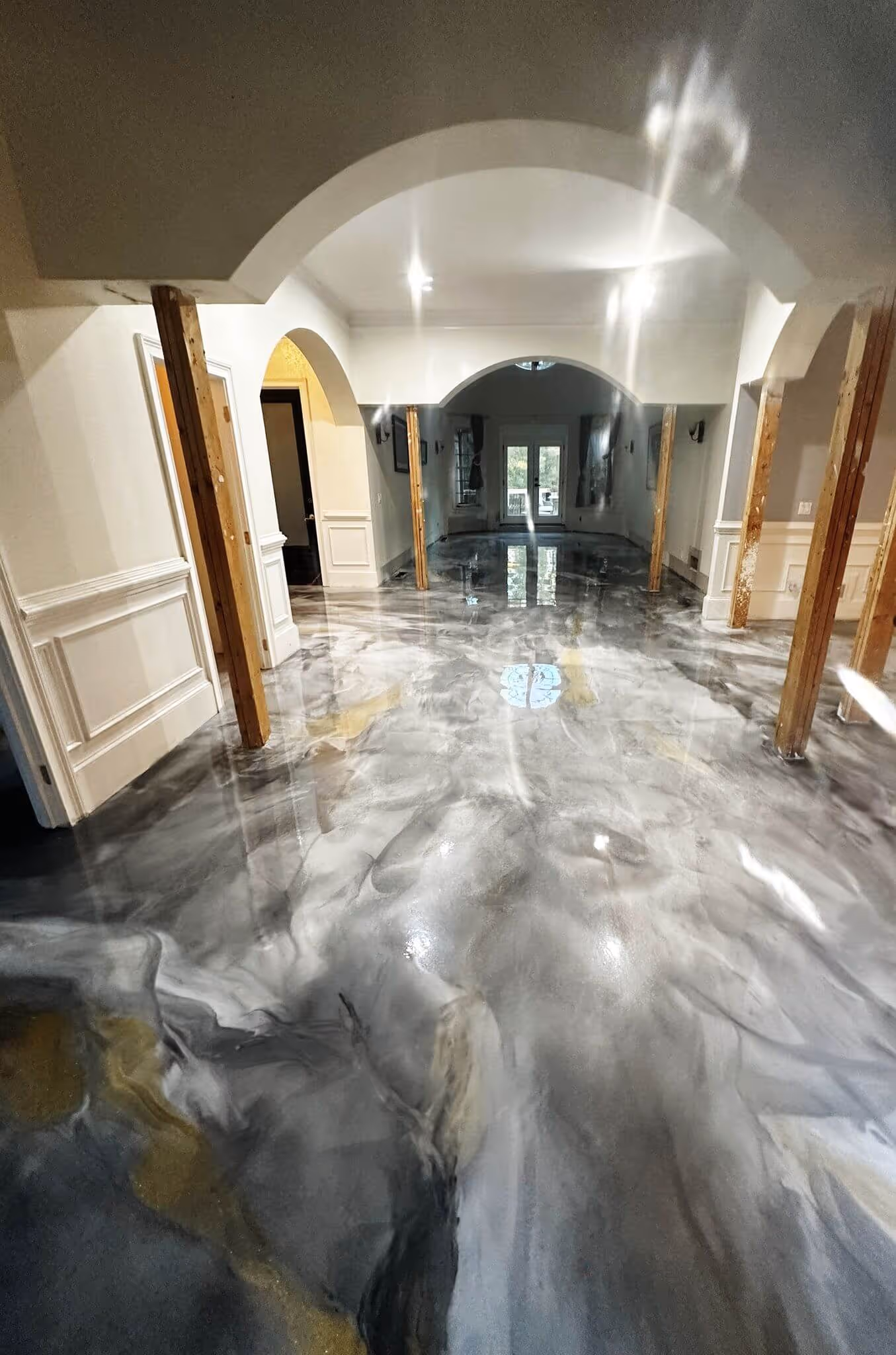 Marbled metallic epoxy floor in a Sugar Hill, GA home with arched doorways