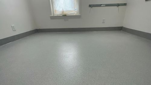 Clean gray quartz epoxy floor coating installed in a corner room.