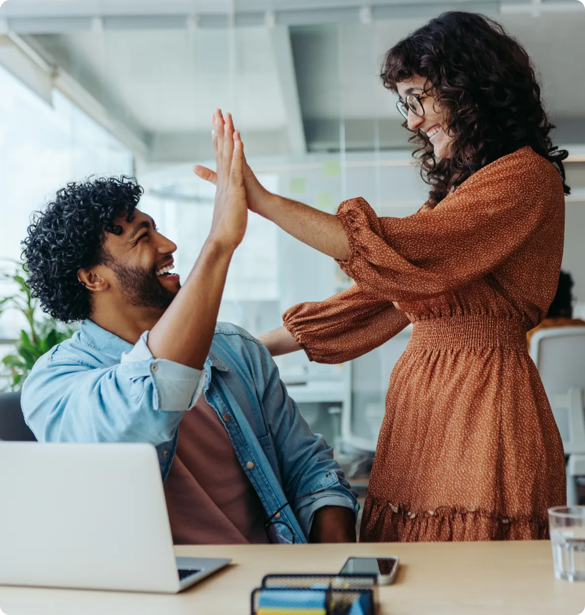 a woman giving a high five to a man in an office