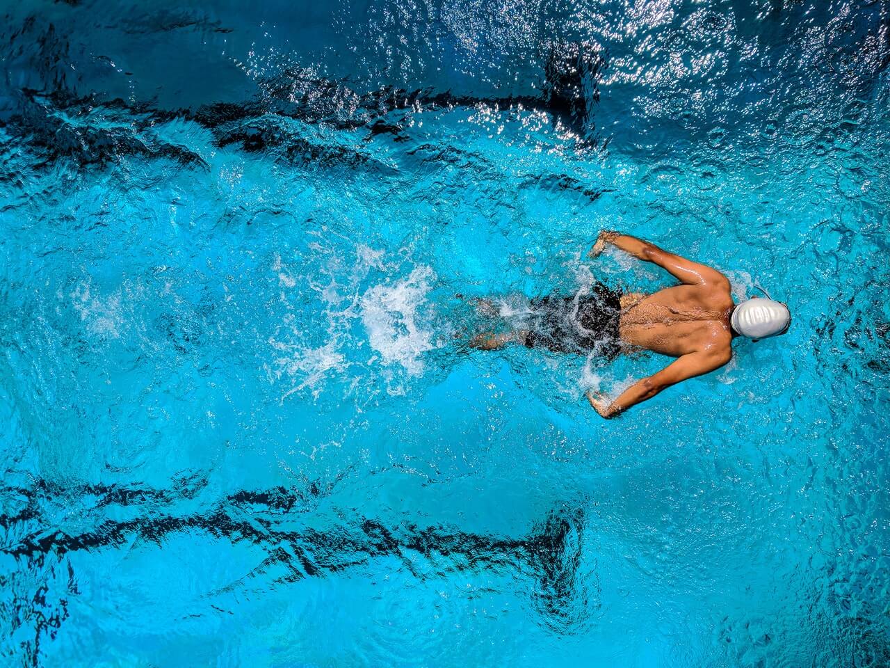 Mann der in einem Sportbecken schwimmt