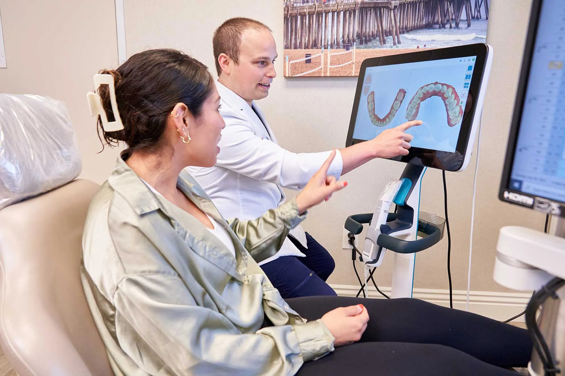 Dr. Andrew Levin showing a patient her Invisalign scan on a digital scanner screen at Surf City Orthodontics