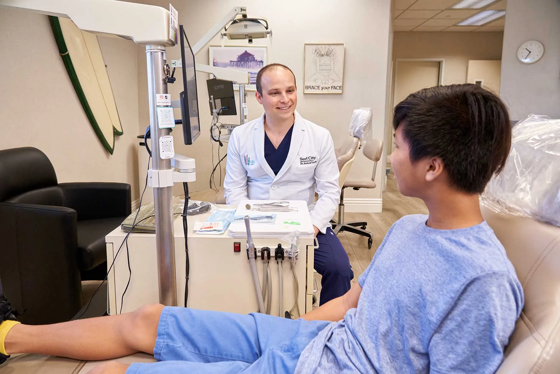 Dr. Andrew Levin talking with a teen patient during an orthodontic visit in Huntington Beach