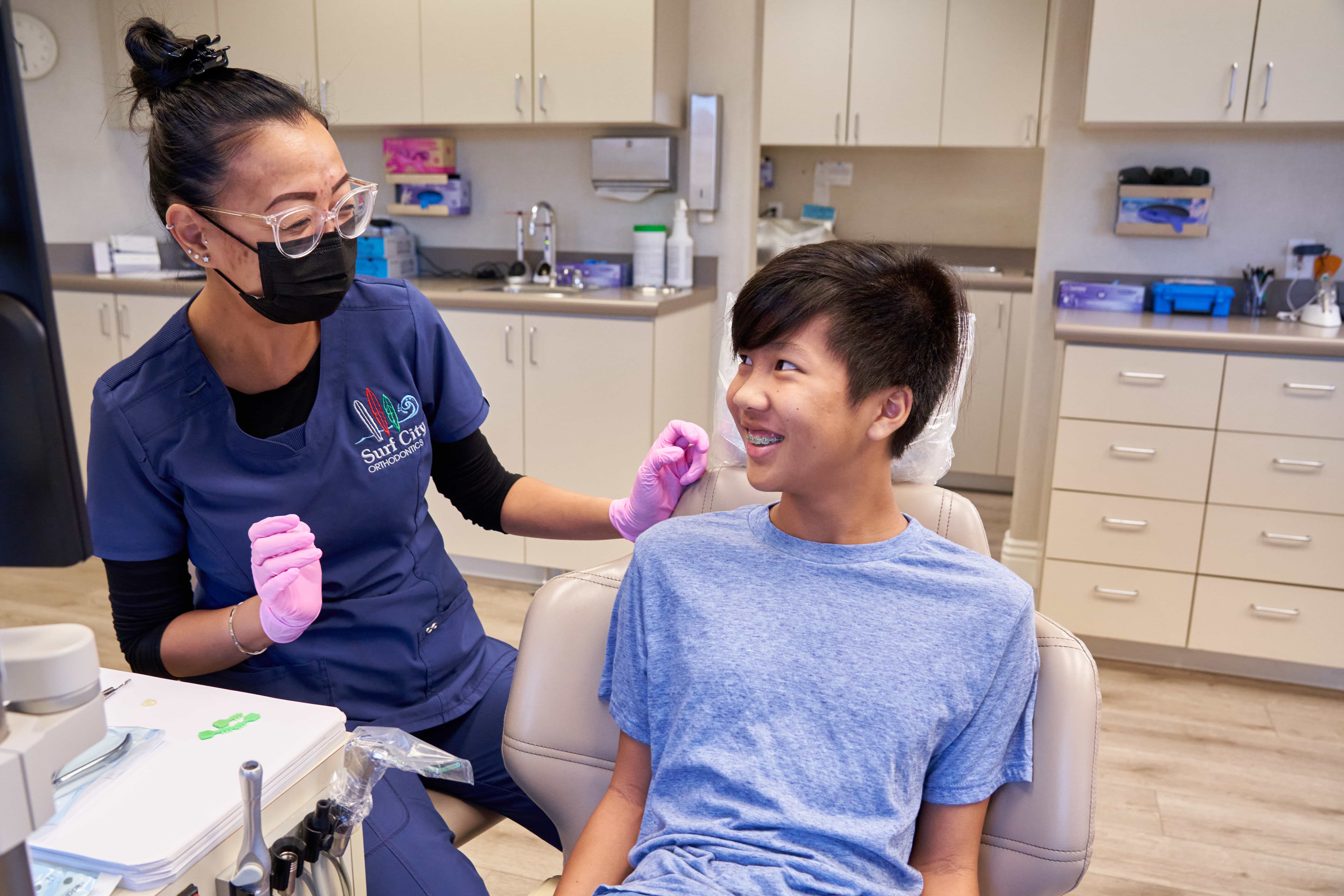 Orthodontic assistant chatting with a teen patient in the treatment chair at Surf City Orthodontics