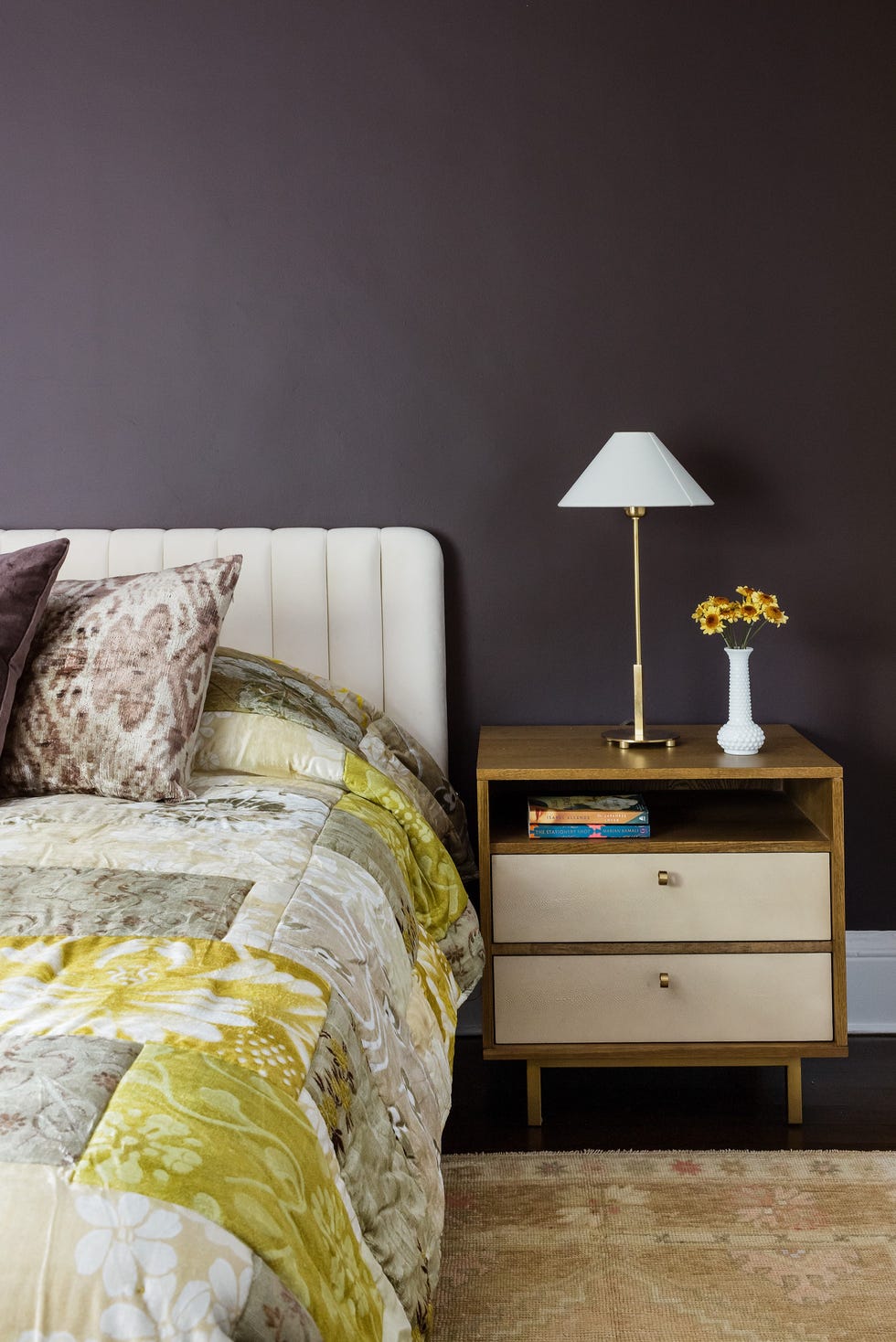 a cozy bedroom setup featuring a bed nightstand lamp and decorative elements