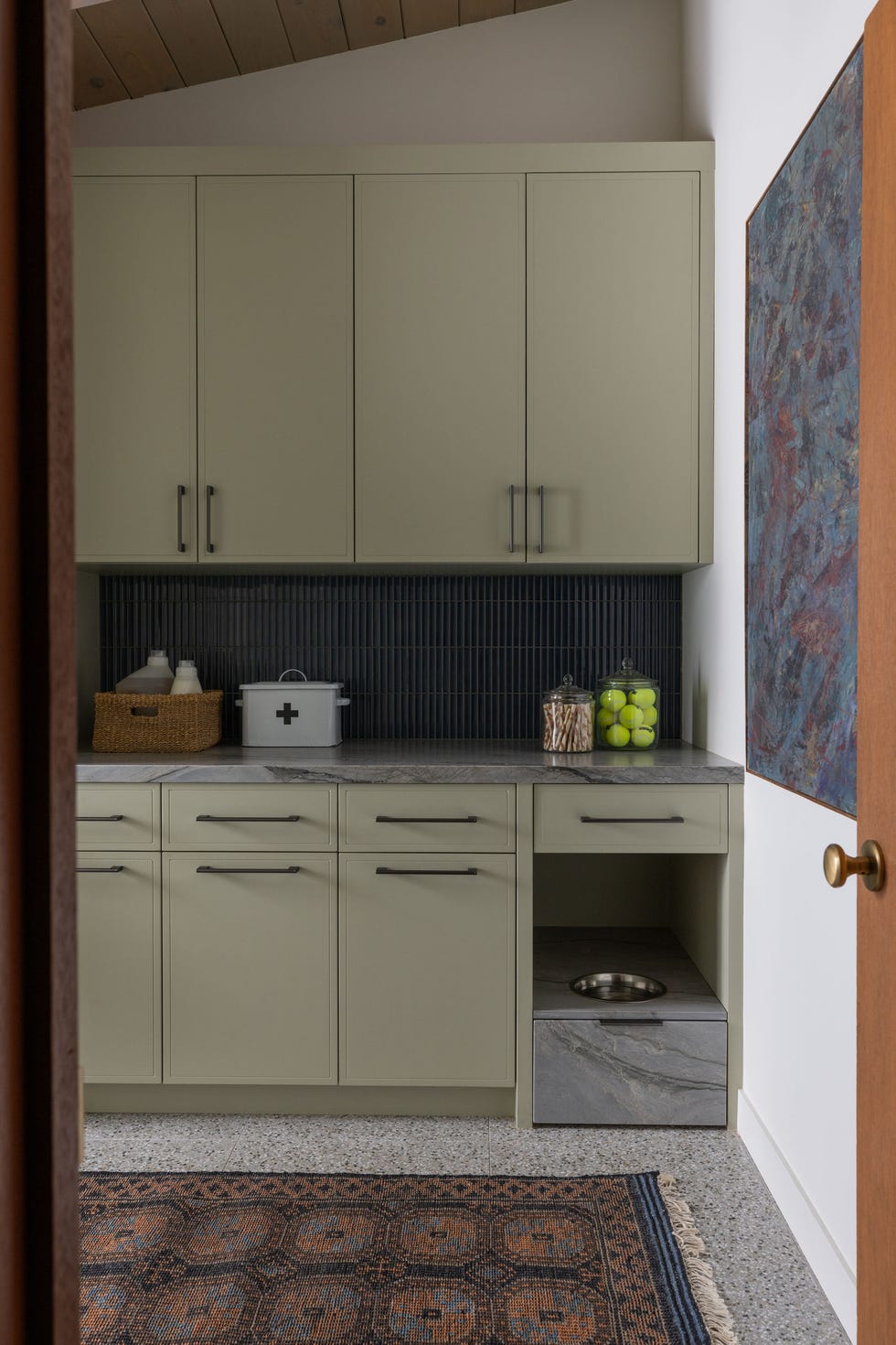 modern kitchen corner with cabinets countertop and pet feeding area