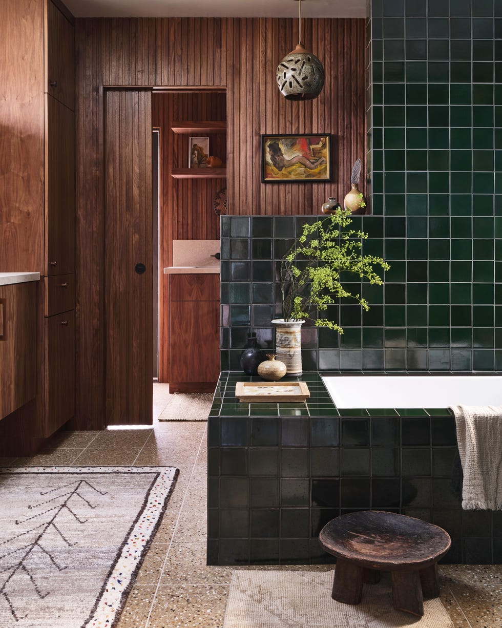 a1000xbetter bathroom with built in bath surrounded by black tiles