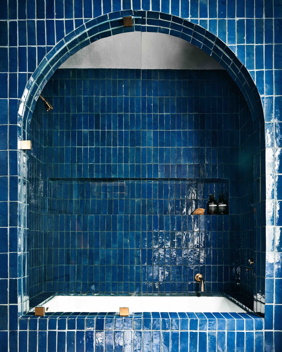 bath set into arched alcove and clad in blue zellige tiles