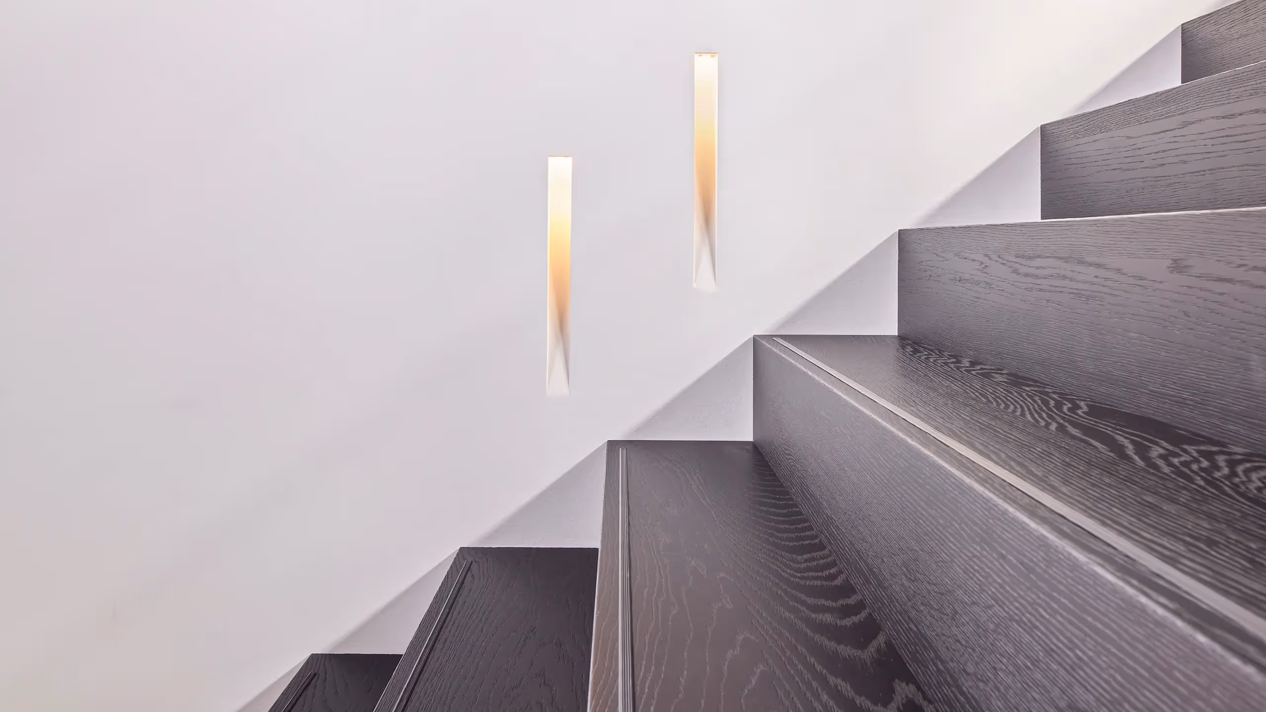 Trap met tijdloos wandarmatuur als oriëntatieverlichting.