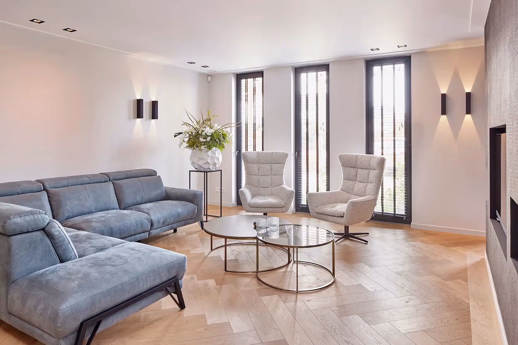 Woonkamer met wand- en plafondverlichting ter ondersteuning van daglicht.