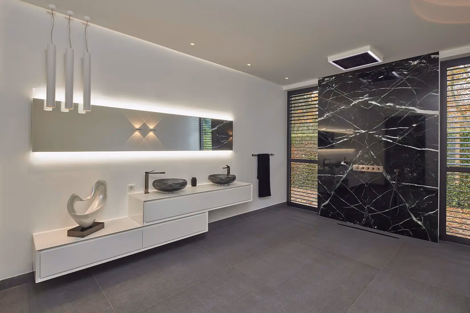 badkamer met subtiele plafondspot en elegant wabdarmatuur met paraboolvormig lichtpatroon. 