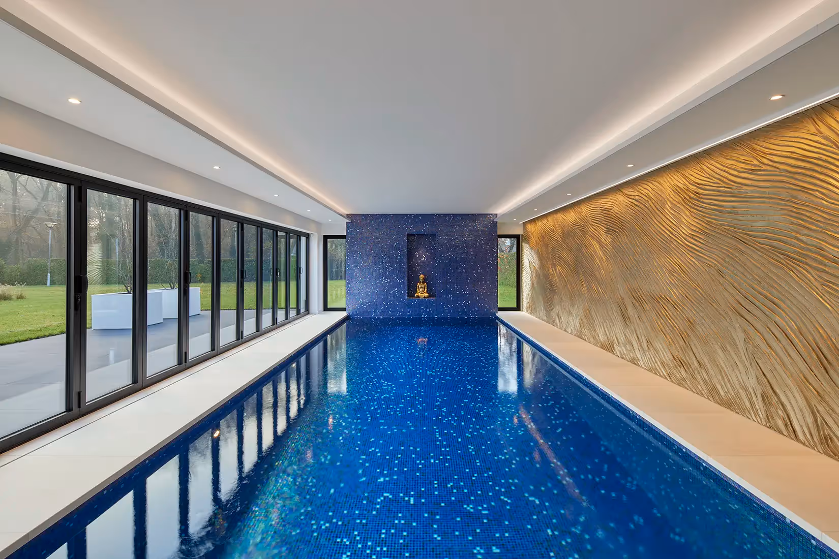 Binnenzwembad met lichtlijnen en plafondspots.