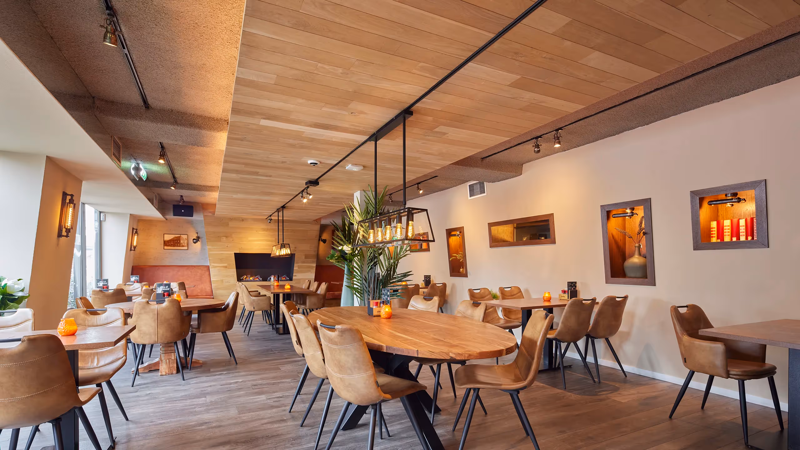 Restaurantruimte met wand- en plafondverlichting.