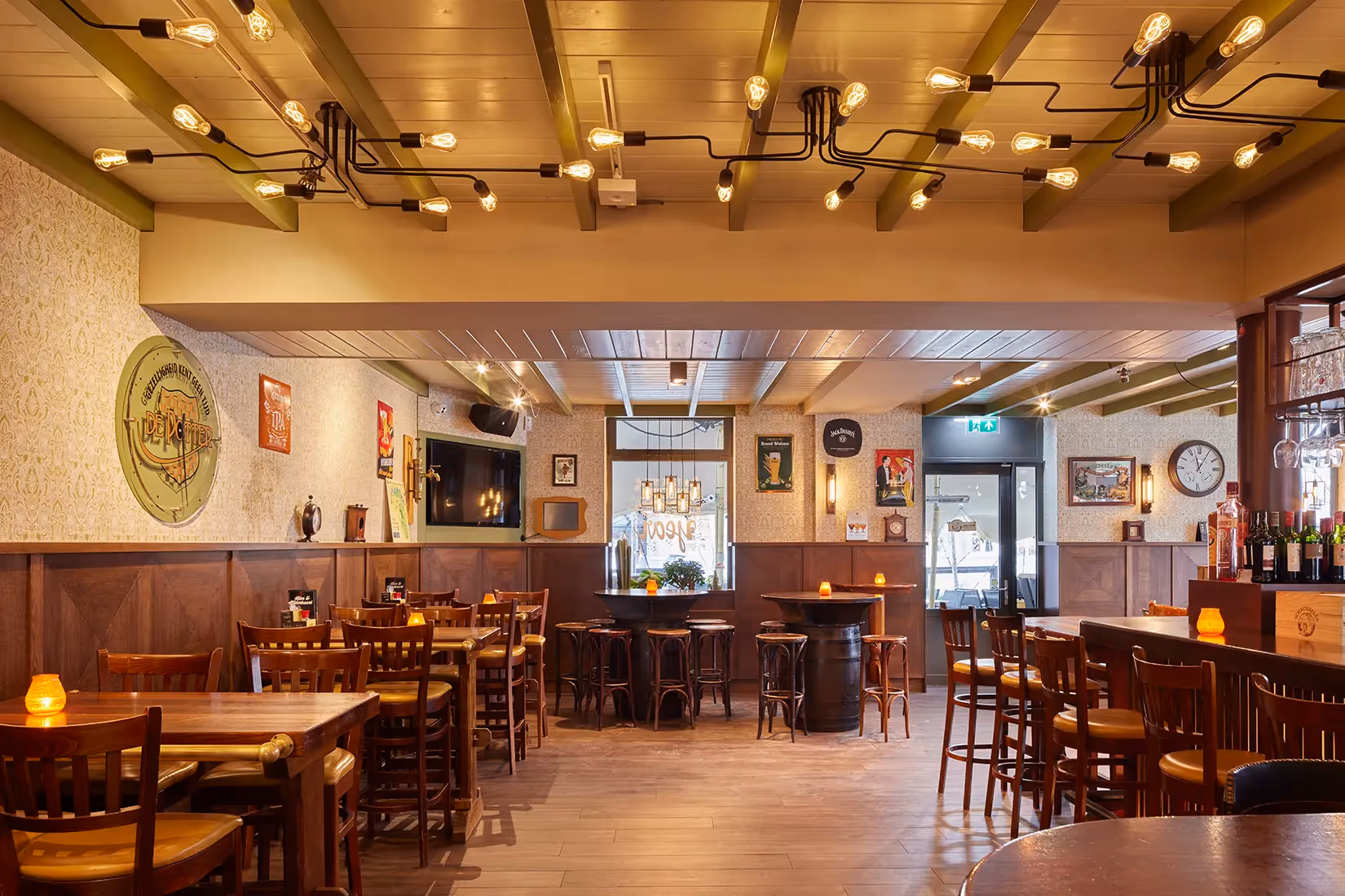 Bruin cafe met industriele wand- en plafondverlichting.