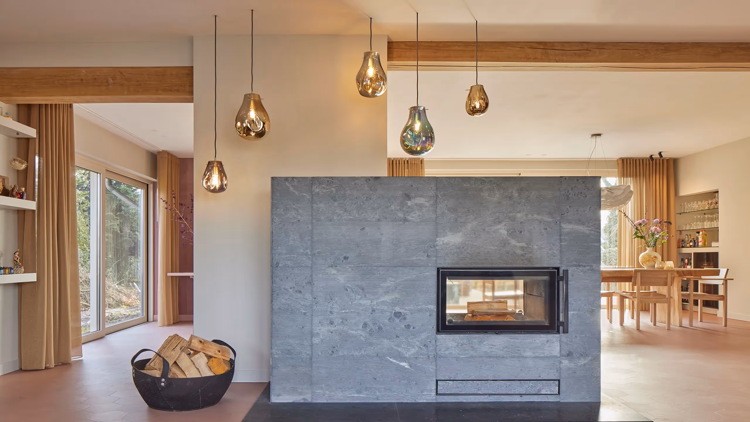 Woonkamer met mondgeblazen glazen hangarmaturen boven een houthaard.