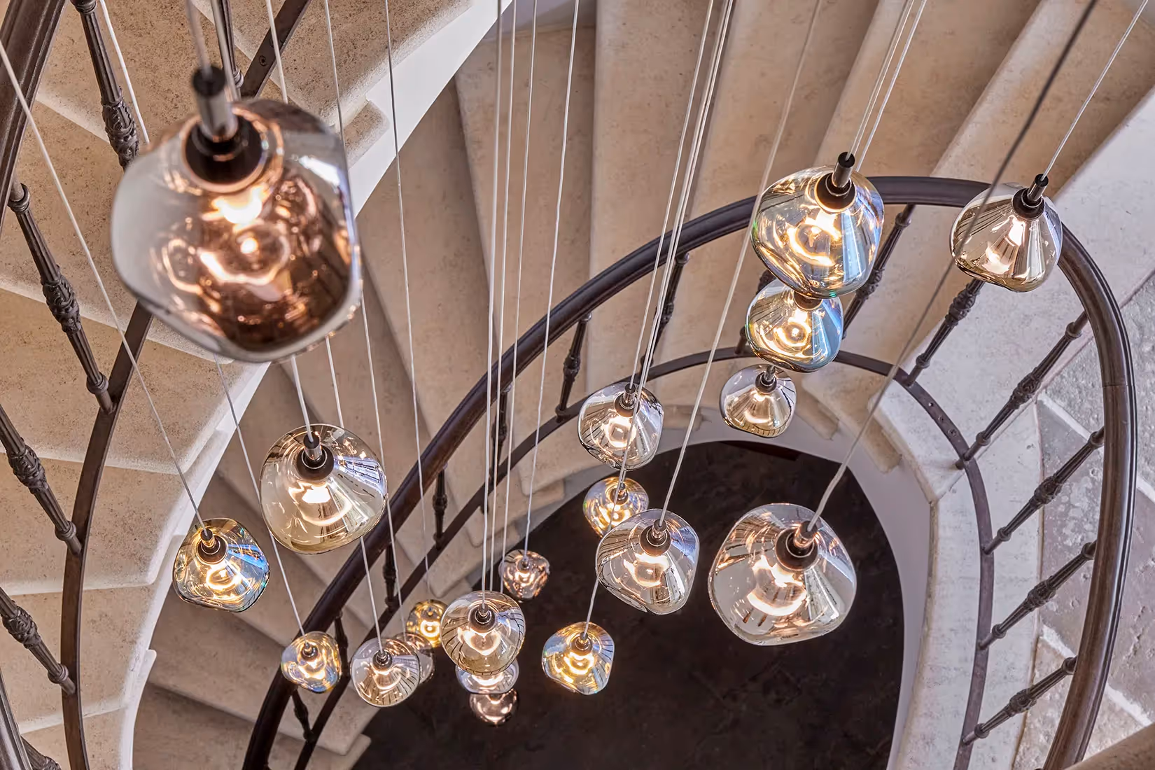 Lichtconstellatie van hangarmaturen binnen een wenteltrap ingeschakeld vanaf bovenaanzicht.