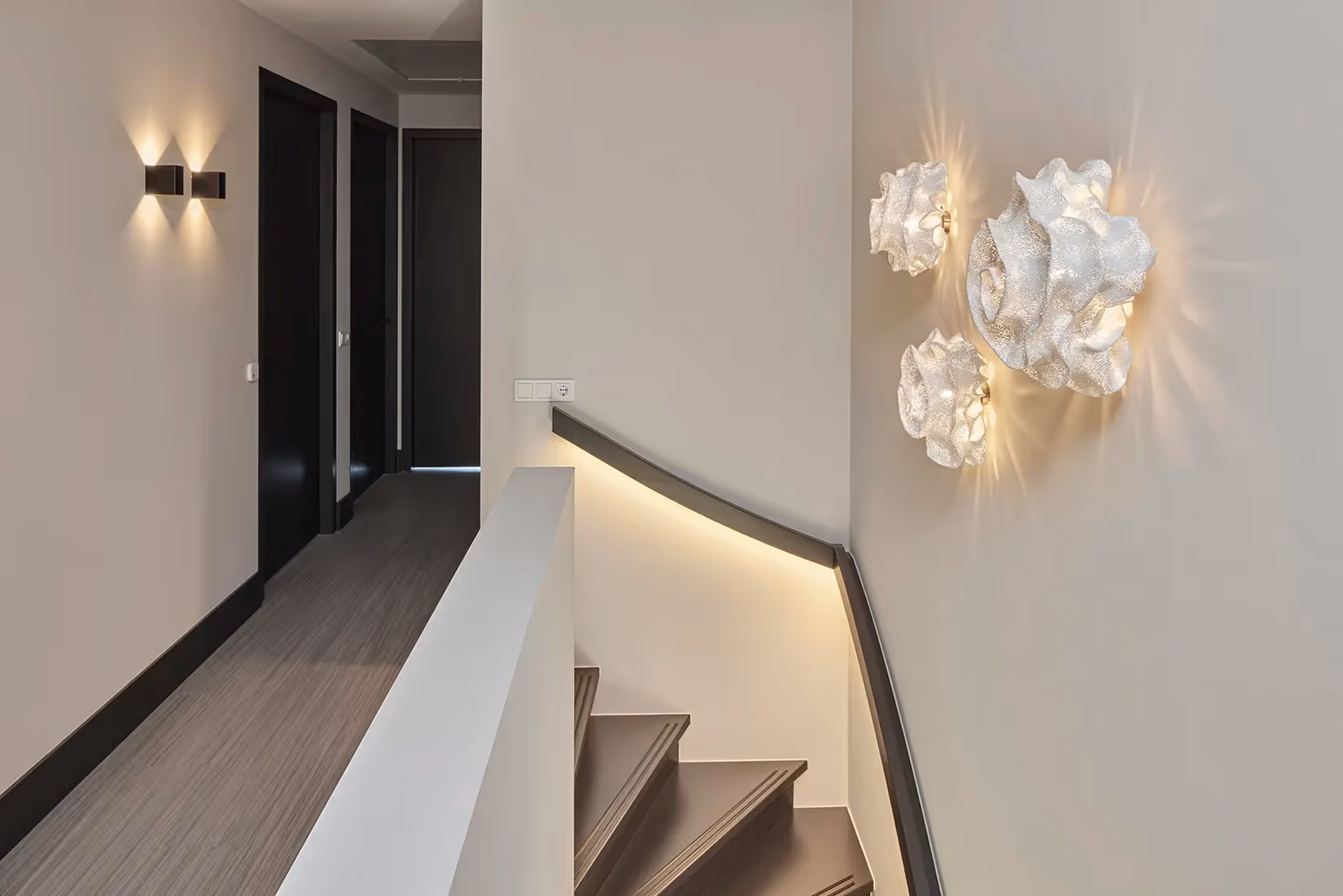 Overloop met opbouw duo wandarmatuur en organisch gevormde wandlampen.