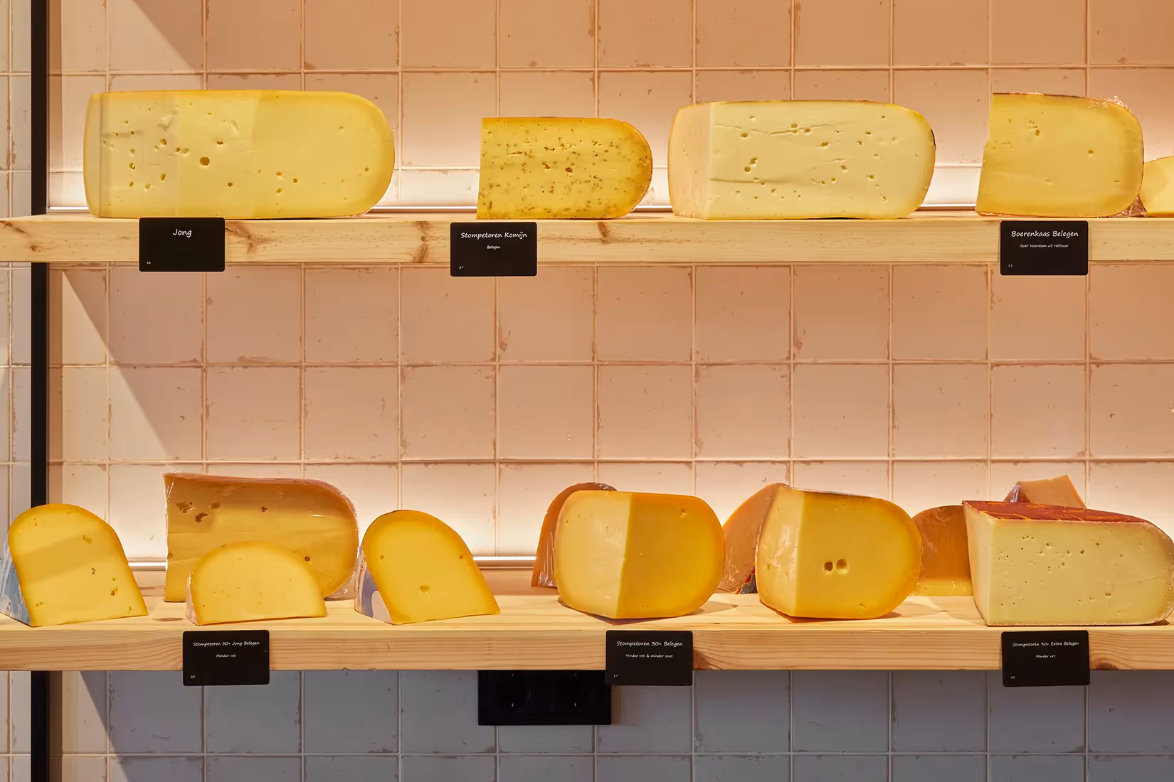 Productuitlichting op schappen in een kaaswinkel.