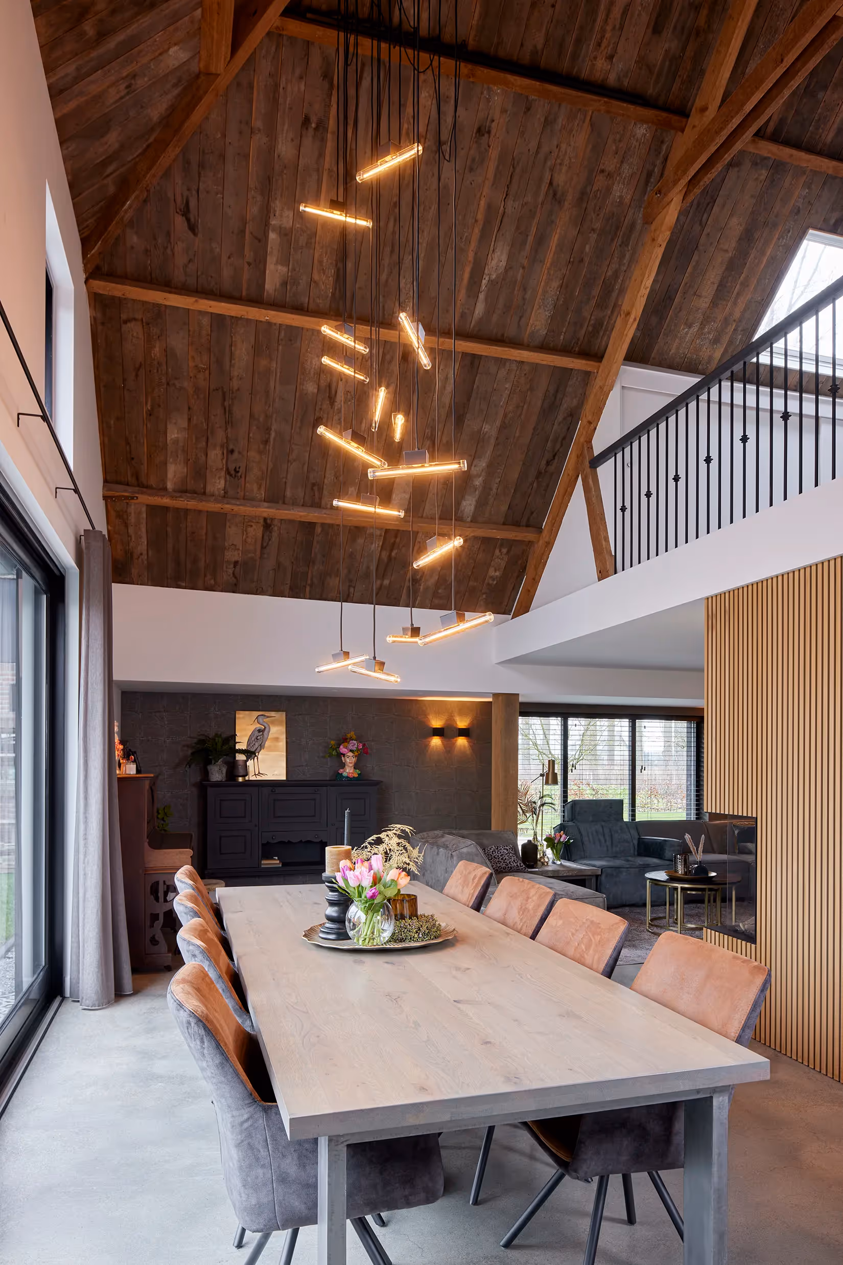 Gegroepeerde hanglamp met nostalgische look op verschillende niveaus boven een eetafel.