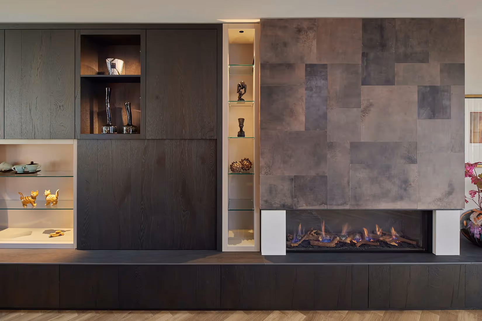 Wandmeubel met vitrine en nisverlichting.