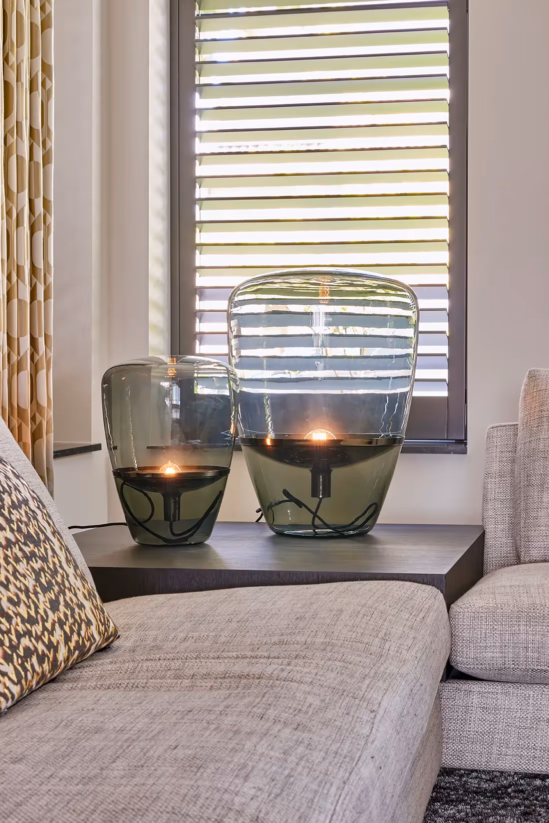 Stoere glazen tafellampen met warm lichtbeeld.