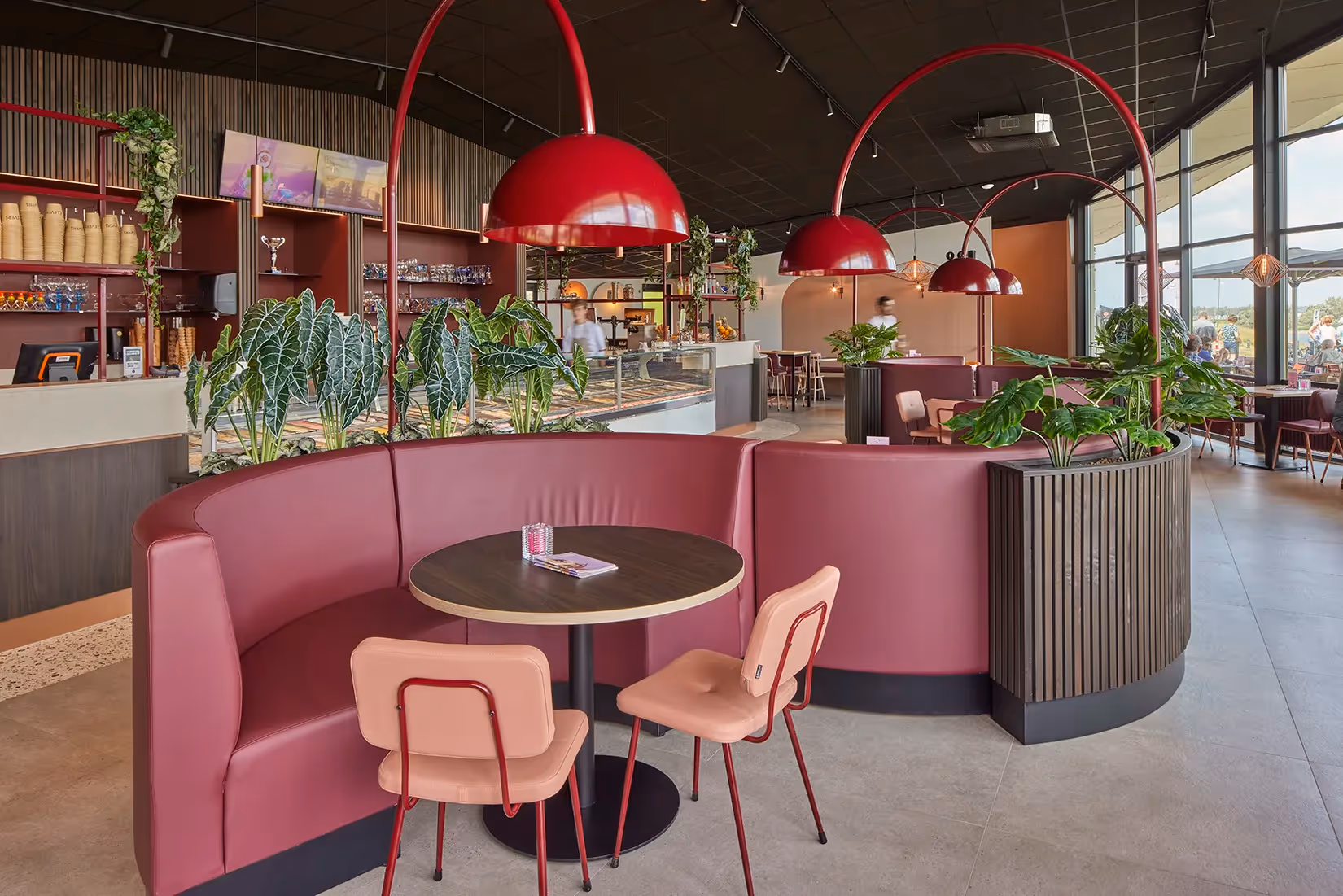 Tafelverlichting boven een gebogen zithoek van een ijssalon.