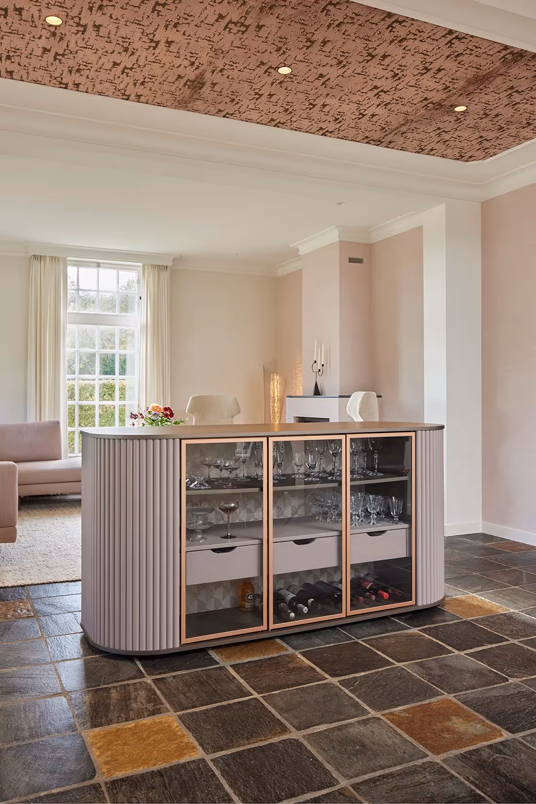 Ruimtescheidend meubelstuk met daarboven plafondspots als basisverlichting.