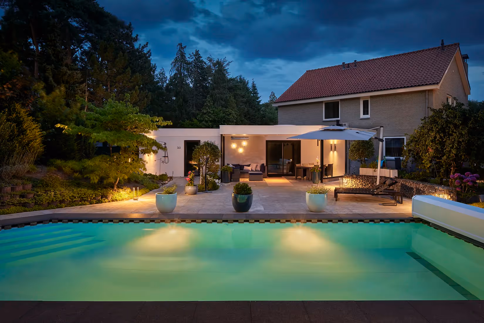 Luxe verlichting voor poolhouse, overkapping en tuin door gebruik van plafond-, wand-, vloer- en grondarmaturen.