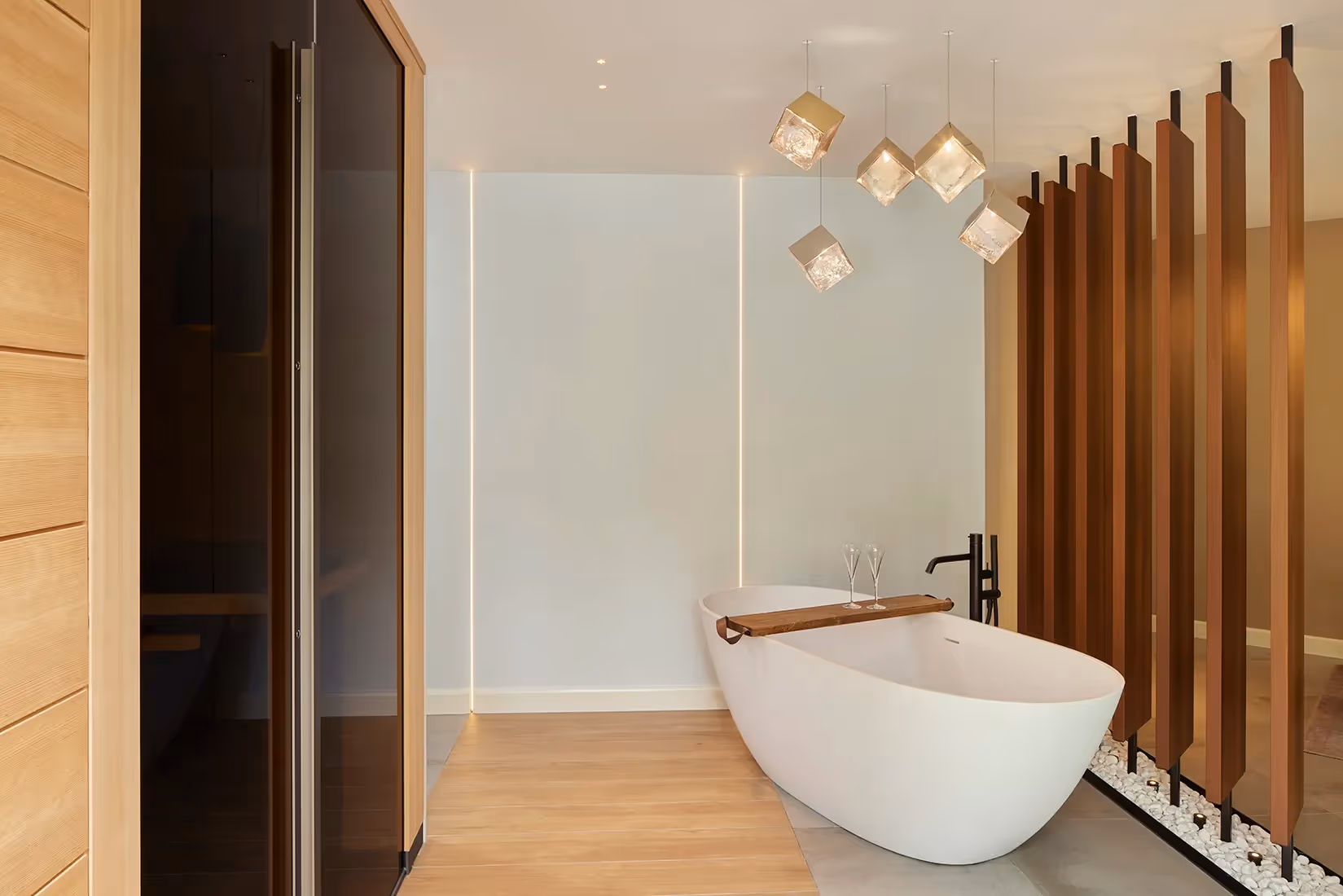 Badkamer met verzonken lichtlijnen en luxe hangarmaturen.