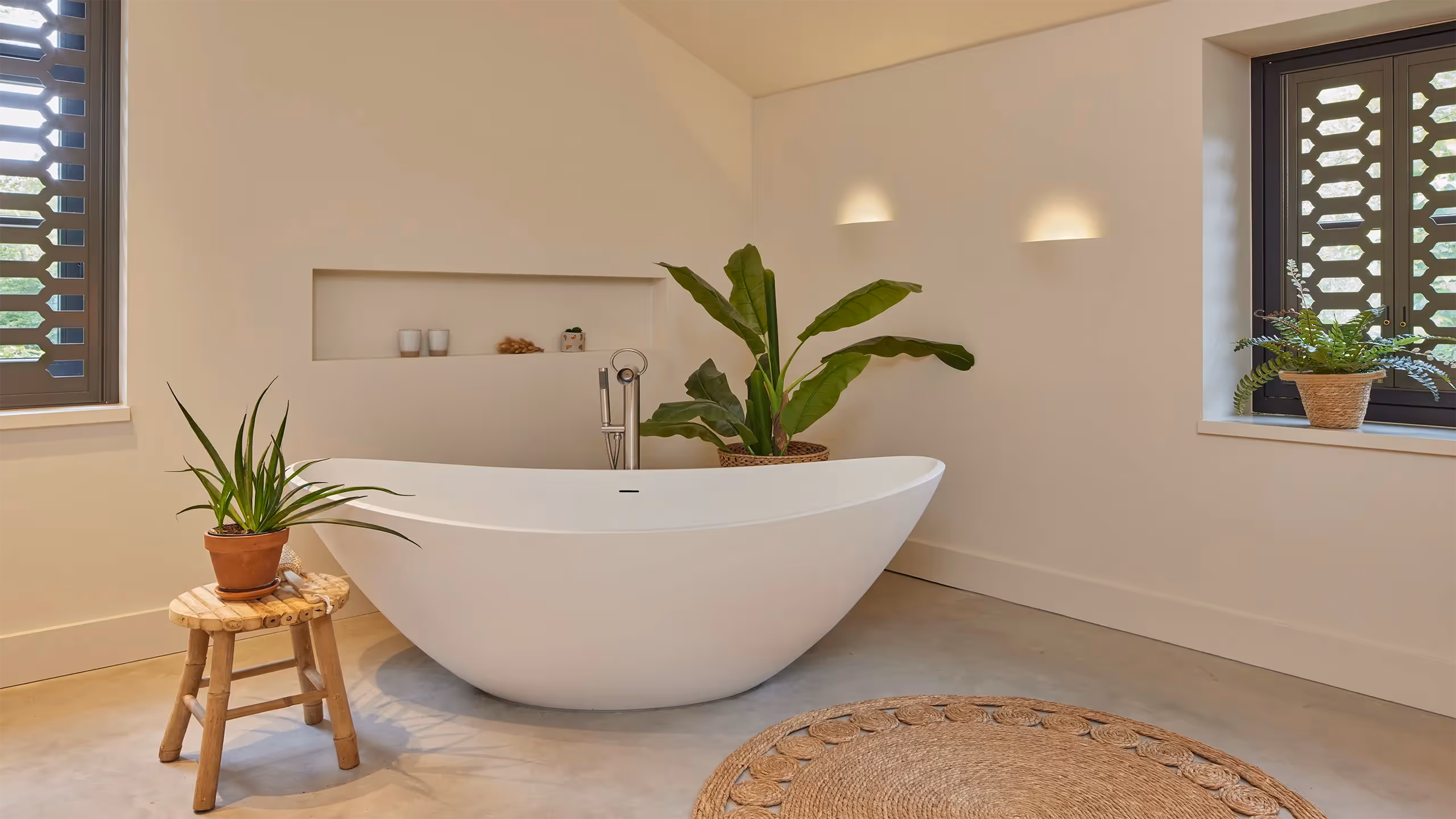 Badkamer voorzien van ingestucte wandverlichting met sfeervol lichtbeeld.