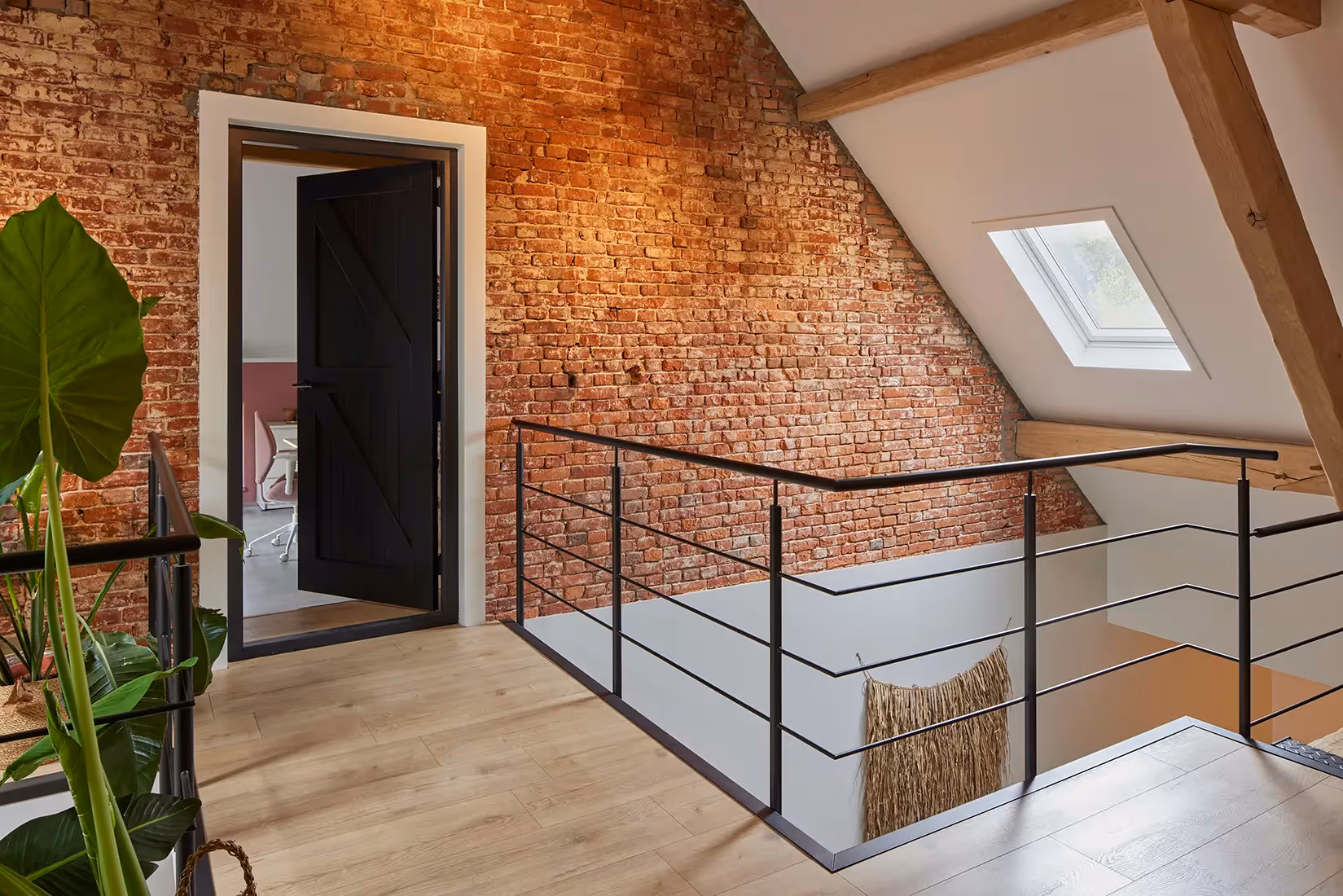 Vide met dakvenster en plafondverlichting die schoon metselwerk uitlicht.