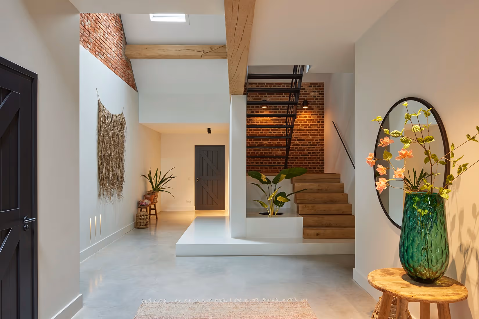 Entree met plafond- en wandverlichting die zowel sfeerverhogend als functioneel is ingezet.