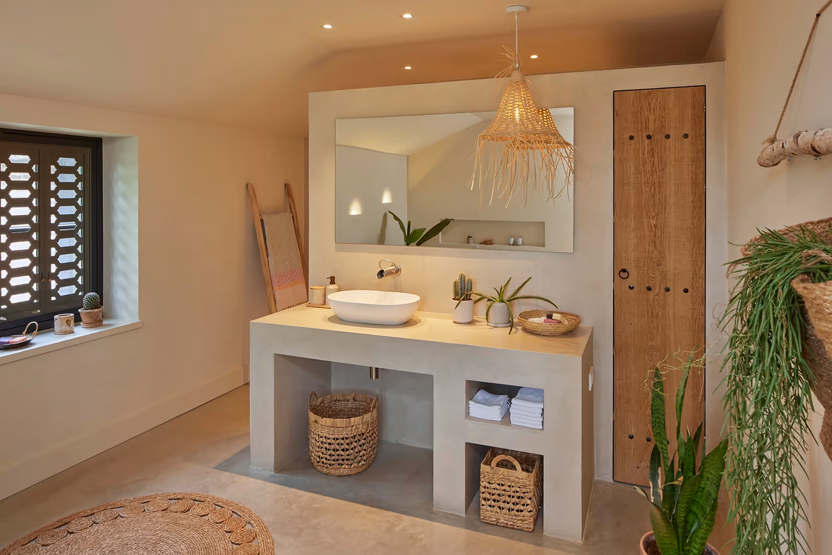 Badkamer met ingebouwde basisverlichting en hanglamp met natuurlijke look.