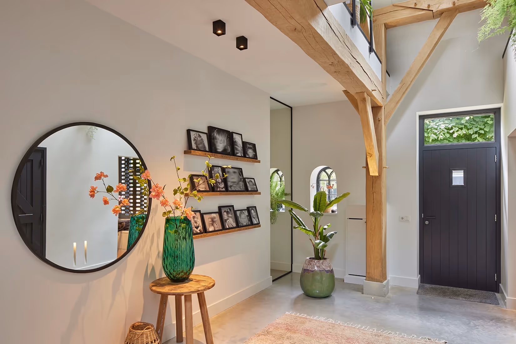 Entree met opwaartse belichting van houten dakconstructie.