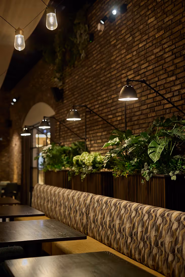 Wandarmaturen boven restauranttafels.