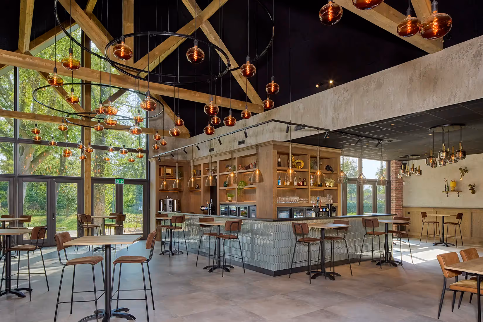 Hoge ruimte met plafond en barverlichting.