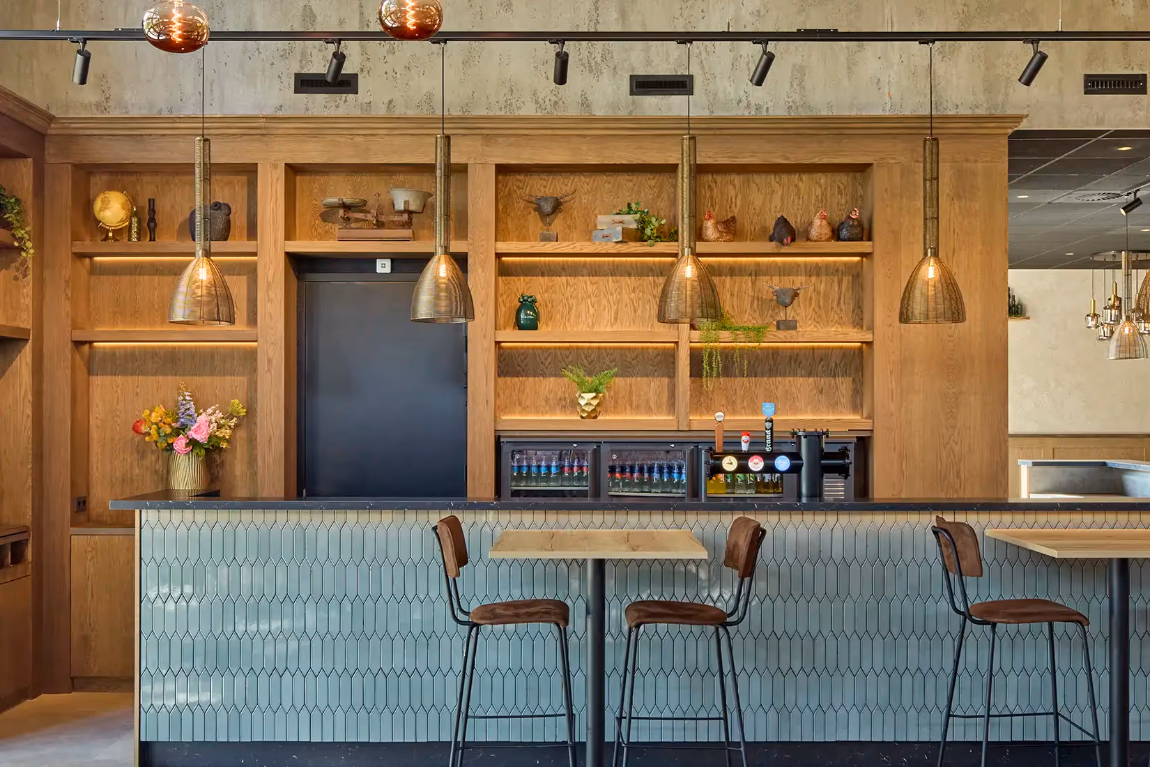 Verlichting en railsysteem met richtspots boven een bar.