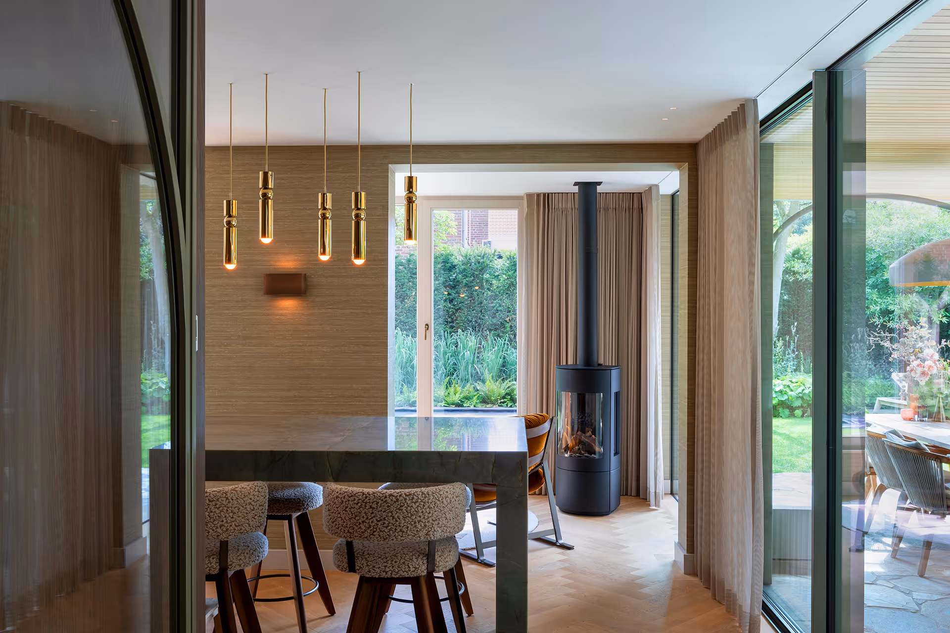 Marmeren eethoek met gepolijst blad, met reeks messing hanglampen.