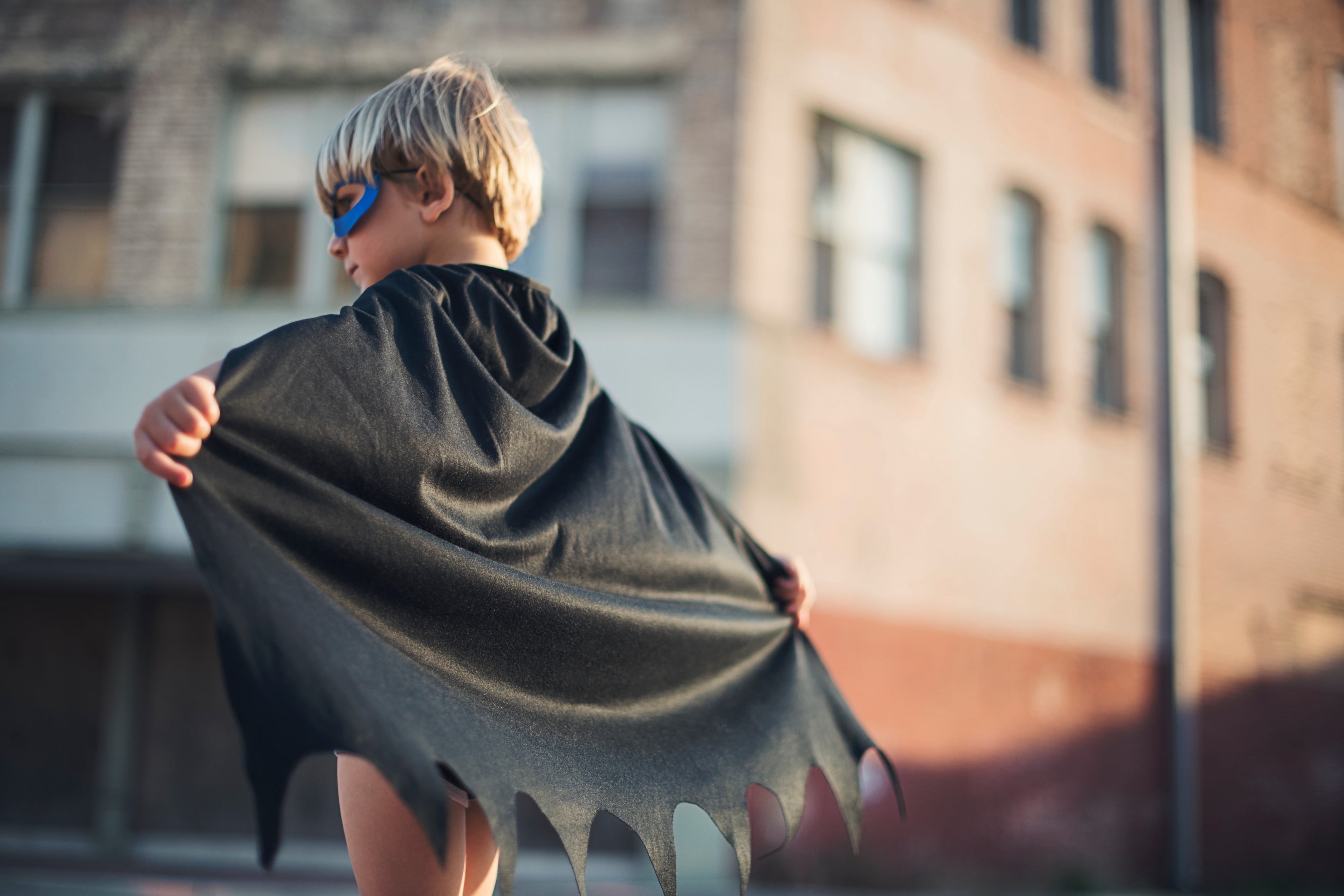 A kid wearing a mask and wing costume, photographed by TK Hammonds