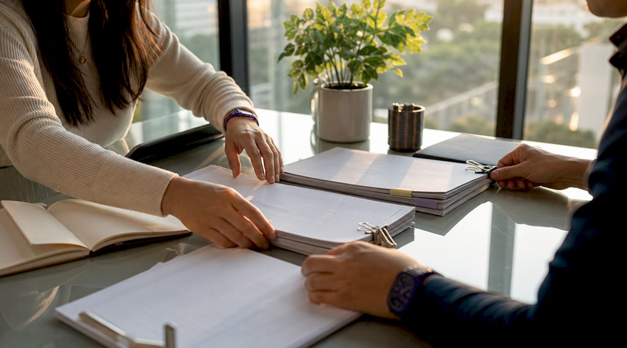 Hands assembling mortgage application documents