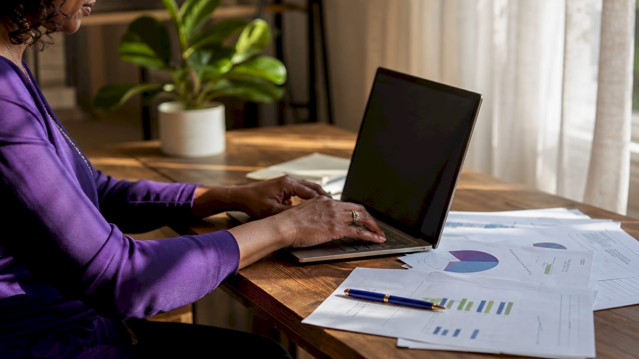 Hands typing near mortgage LTV papers on desk