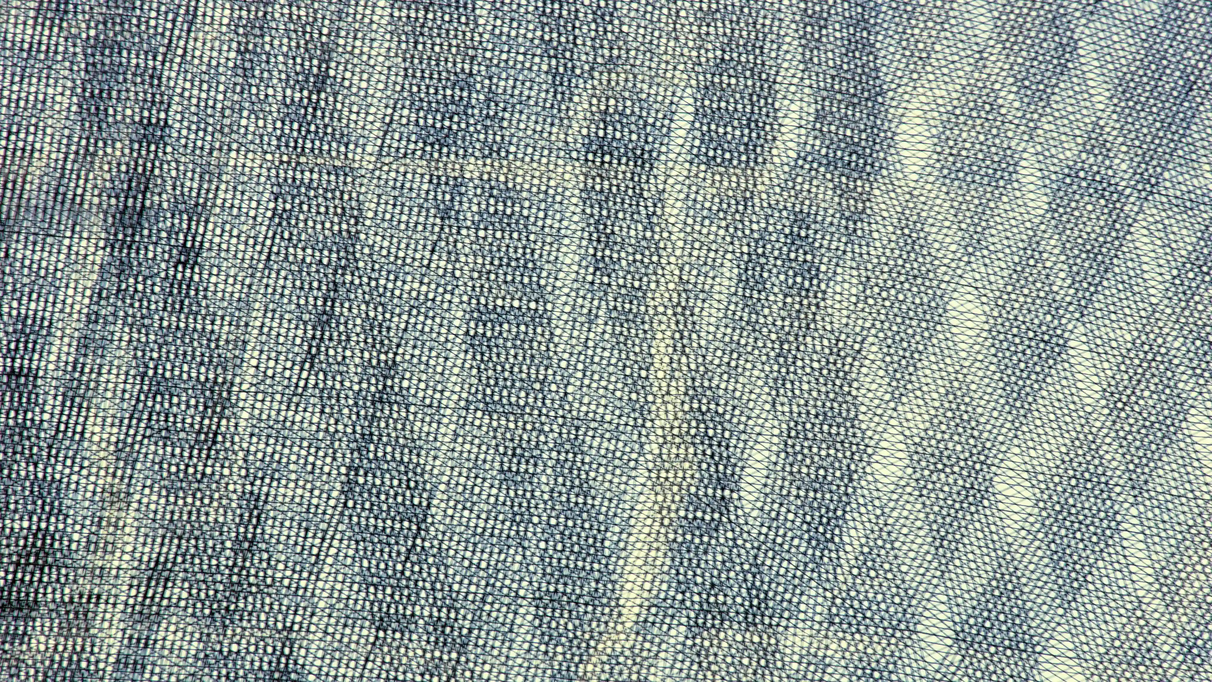 Close-up of woven fabric with intricate blue and beige patterns and crisscrossing threads.