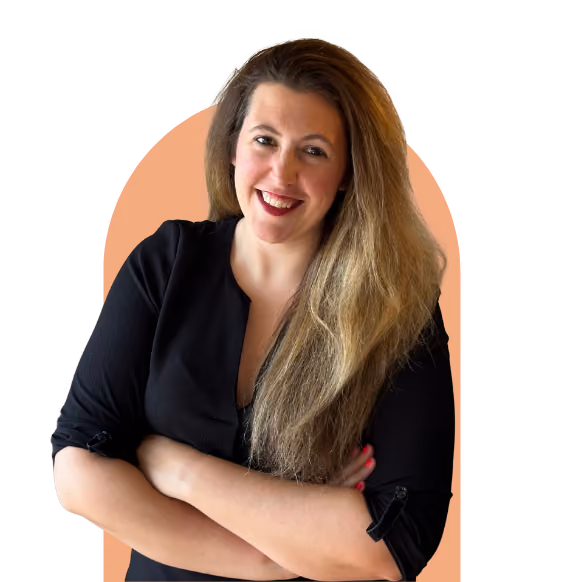 A smiling woman with long, wavy blonde hair wearing a black turtleneck and a gray blazer stands against a teal background. The image promotes online therapy and virtual counselling services, highlighting approachable support.
