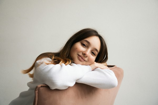 a woman sitting on a chair with her arms crossed