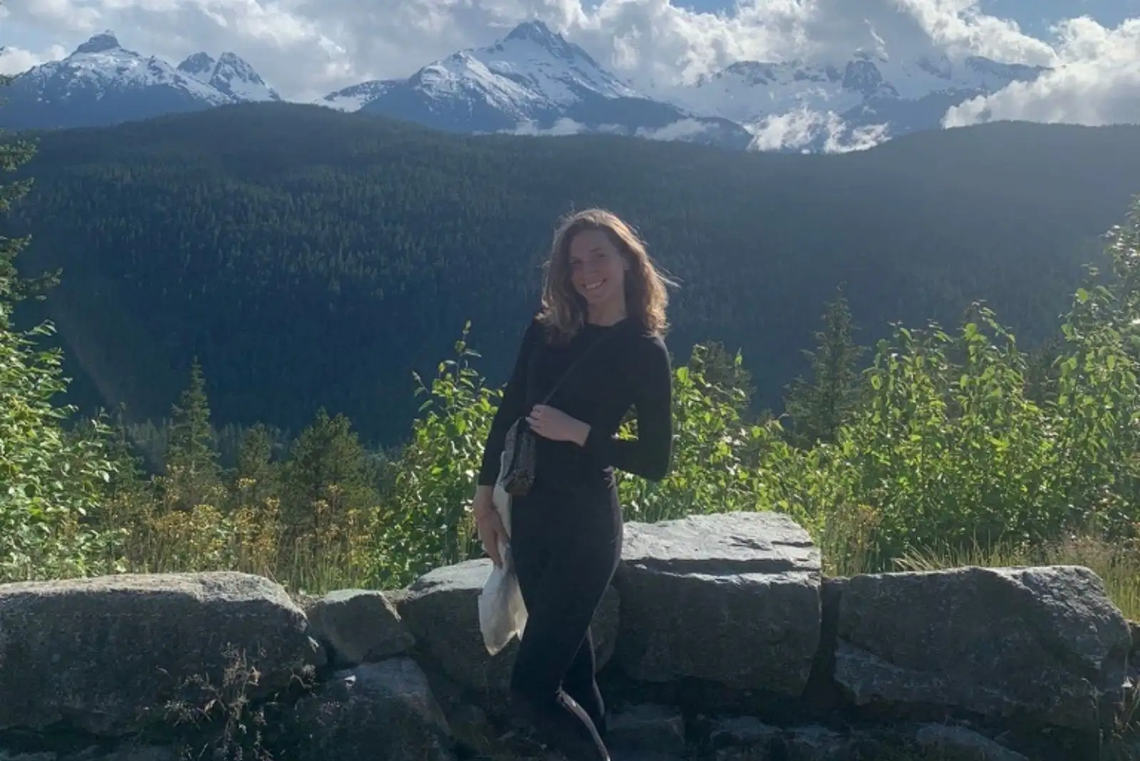 Leah Goldstein smiling with mountains and water in the background.