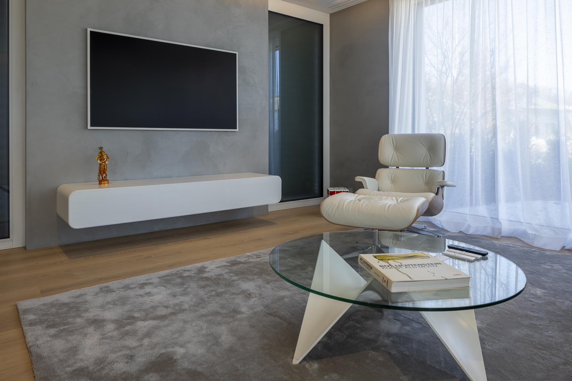 TV-Möbel ist formal und von der Funktion her exakt auf die Bedürfnisse abgestimmt. Alle technischen Geräte inklusive Soundbar finden Platz in dem Gerät. Die Stofffront lässt die Lautsprecher dennoch erklingen.