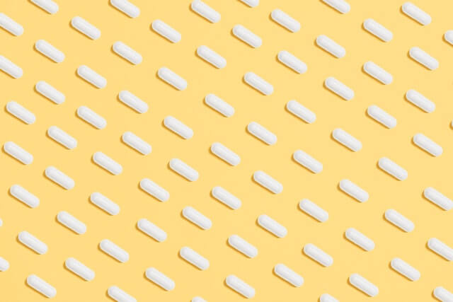 weiße Tabletten auf gelbem Hintergrund 
