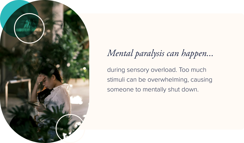 Image: A woman surrounded by large house plants, looking at her phone with one hand on her forehead. Text: Mental paralysis can happen during sensory overload. Too mcuh stimuli can be overwhelming, causing someone to mentally shut down.n